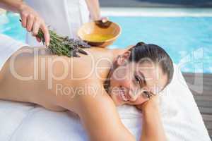 Smiling woman getting an aromatherapy treatment poolside