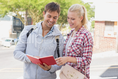 Young tourist couple consulting the guide book