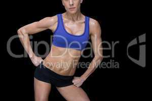 Strong woman posing in sports bra and shorts