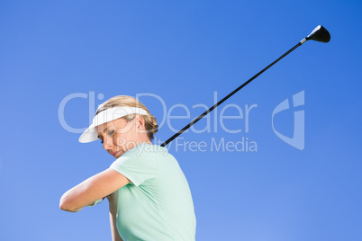 Female concentrating golfer taking a shot