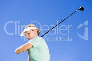 Female concentrating golfer taking a shot