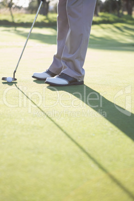 Golfer putting ball on the green