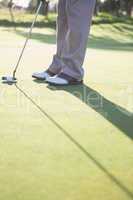 Golfer putting ball on the green