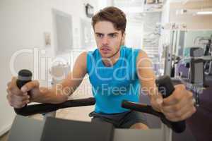 Focused fit man on the exercise bike