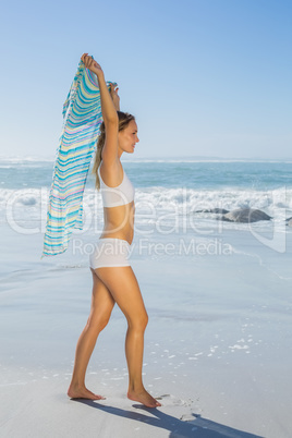 Gorgeous fit blonde walking by the sea with scarf