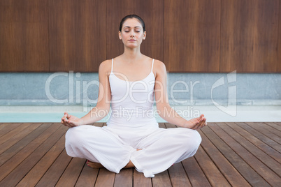 Peaceful woman in white sitting in lotus pose