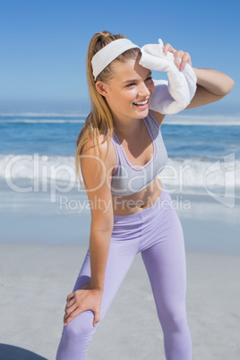 Sporty blonde standing on the beach with towel