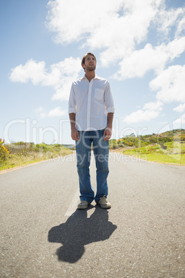 Handsome casual man standing on a road