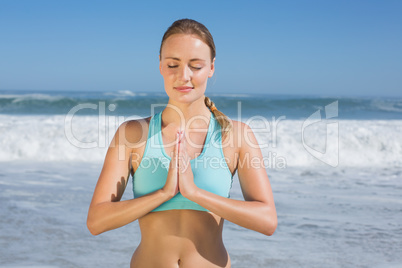 Fit woman meditating on the beach