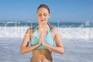 Fit woman meditating on the beach