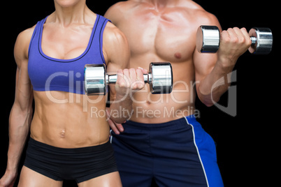 Bodybuilding couple posing with large dumbells