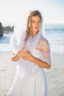 Beautiful blonde in white sundress and scarf on the beach