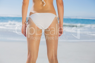 Rear view of fit woman in white bikini on beach