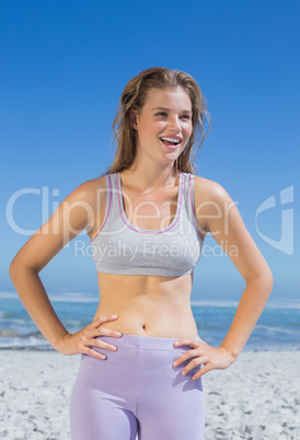 Sporty happy blonde standing on the beach