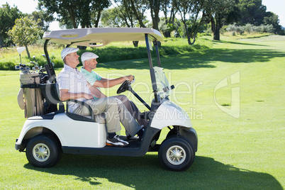 Golfing friends driving in their golf buggy