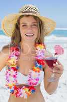 Pretty smiling blonde in floral garland holding cocktail on the