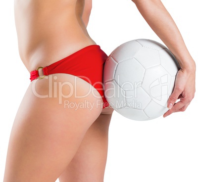 Fit girl in bikini holding football