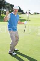 Happy golfer cheering on putting green at eighteenth hole