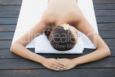 Calm brunette lying on a towel poolside