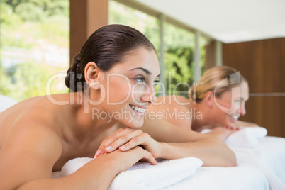 Smiling friends lying on massage tables
