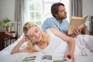 Couple relaxing on bed reading books