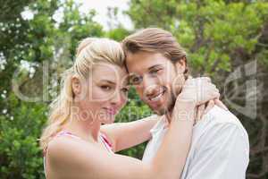 Cute couple standing outside hugging smiling at camera