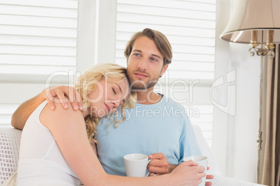 Young couple having coffee on the couch