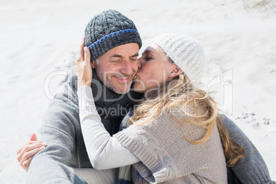 Attractive couple on the beach in warm clothing