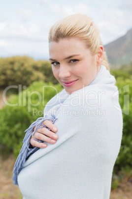 Pretty blonde wrapped up in blanket outside