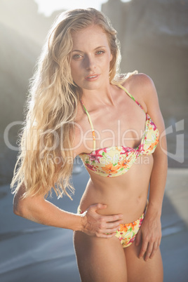 Gorgeous blonde in floral bikini posing on the beach
