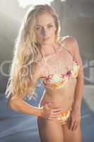 Gorgeous blonde in floral bikini posing on the beach