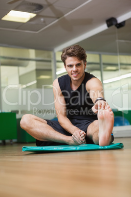 Fit man warming up in fitness studio