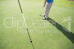 Golfer putting ball on the green