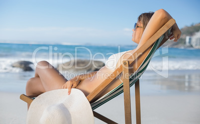 Pretty woman relaxing in deck chair on the beach