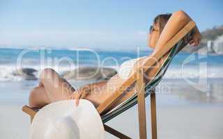 Pretty woman relaxing in deck chair on the beach