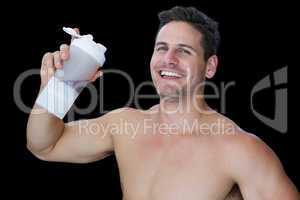 Happy muscular man holding protein drink