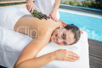 Smiling woman getting an aromatherapy treatment poolside