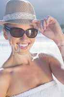 Pretty blonde in white dress and sunhat on the beach