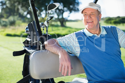 Happy golfer driving his golf buggy