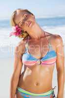 Gorgeous blonde in bikini on the beach bending neck