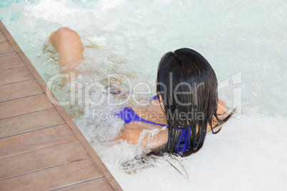 Brunette in bikini relaxing in hot tub