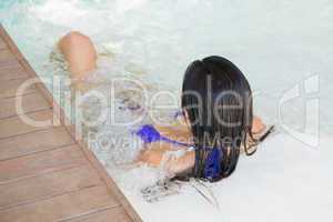 Brunette in bikini relaxing in hot tub