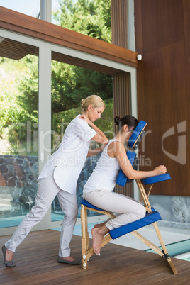 Relaxed brunette getting a massage in chair