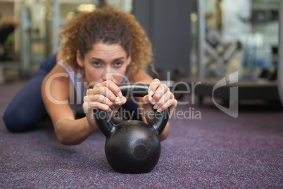 Fit woman lying with kettlebell