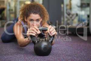 Fit woman lying with kettlebell