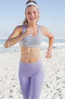 Sporty blonde jogging on the beach