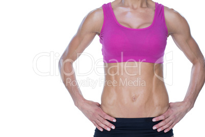 Female bodybuilder posing with hands on hips mid section