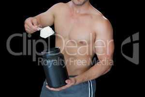 Muscular man scooping up protein powder