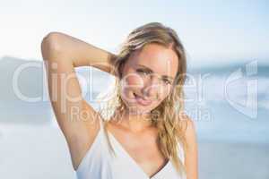 Pretty blonde standing at the beach in white sundress