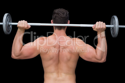 Serious crossfitter lifting up barbell behind head Serious crossfitter lifting up barbell behind head